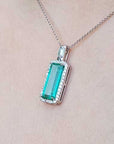 Emerald pendant necklace on a light skin background