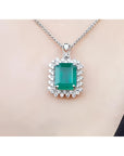 Emerald pendant necklace halo diamond on a white gold chain, skin background
