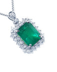 A Colombian emerald pendant necklace with halo natural diamond in white gold topside view.