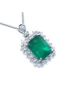 A Colombian emerald pendant necklace with halo natural diamond in white gold topside view.