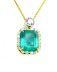 The topside view of a natural colombian emerald square shape surrounded by a halo diamond, made of 18k yellow gold.