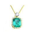7.09 ct. natural emerald pendant with diamond halo and round purple gemstone on 18K yellow gold chain.