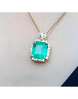 18K yellow gold necklace with a large emerald-cut emerald pendant surrounded by a halo of diamonds.