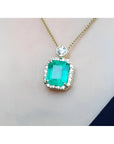 18K yellow gold necklace with a large emerald-cut emerald pendant surrounded by a halo of diamonds.