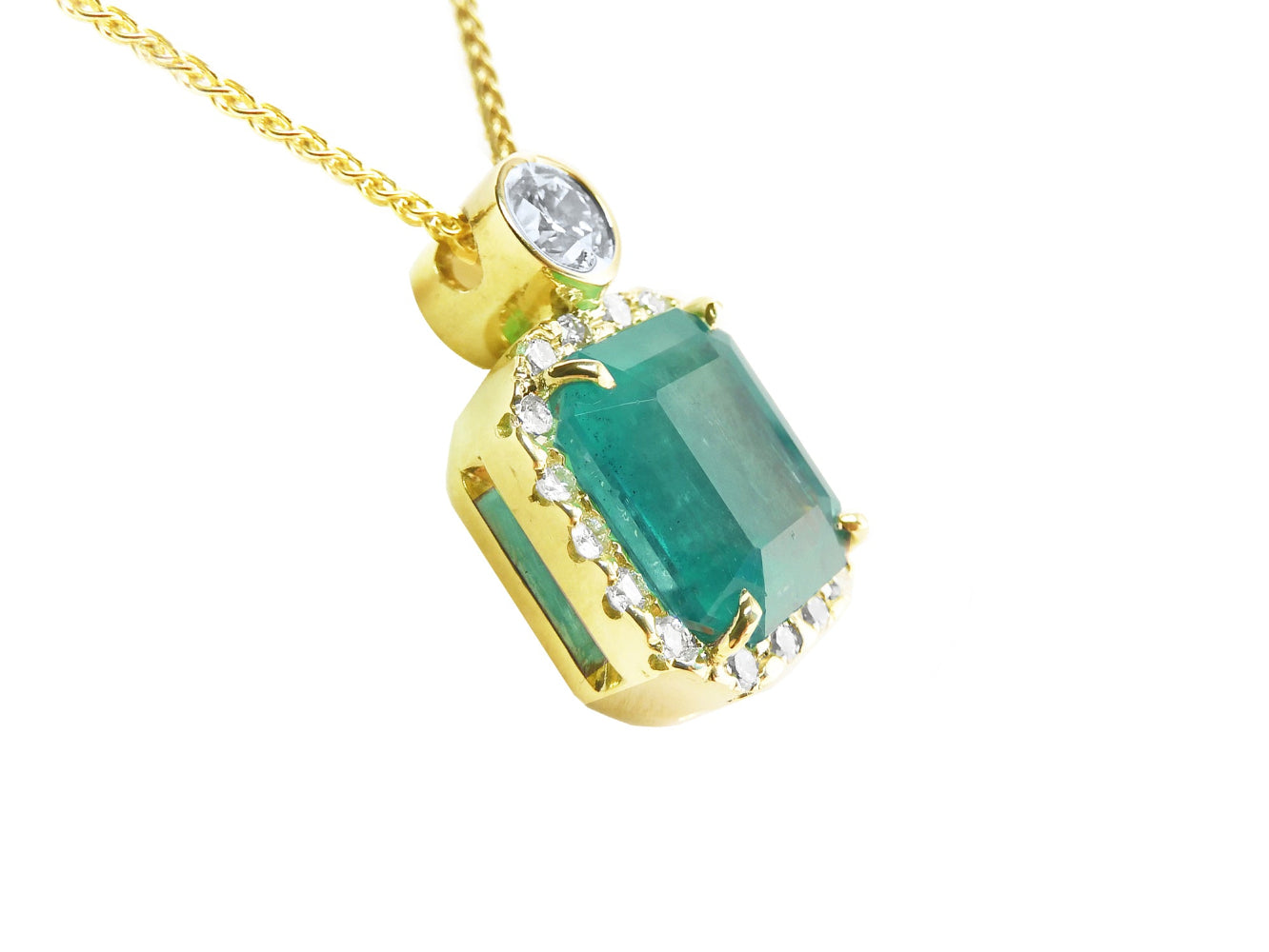 The right-side profile of a yellow gold emerald pendant, top and gallery visibles.