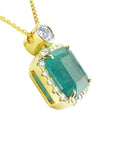 The right-side profile of a yellow gold emerald pendant, top and gallery visibles.