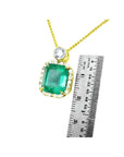 7.09 ct natural emerald pendant necklace with halo diamonds in 18K yellow gold, shown with a ruler for size.