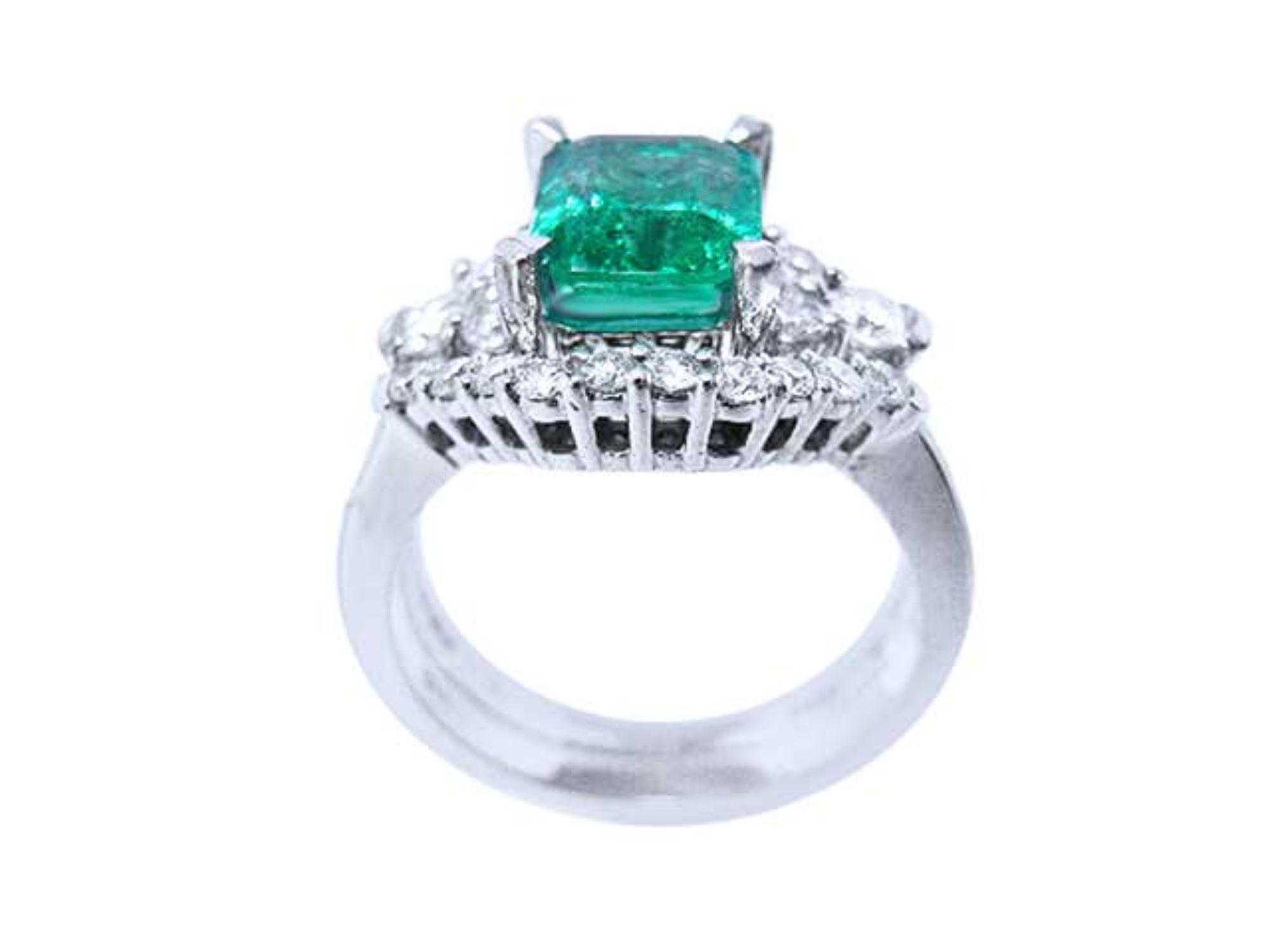 The white gold matching band with diamonds lateral profile in front of the emerald engagement ring.