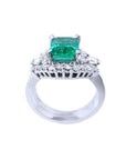 Emerald-cut vivid bluish green emerald ring in white gold, flanked by diamonds.