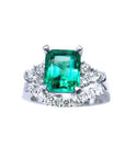 The topside view of the emerald and side diamonds ring whit the match wedding band in white gold.
