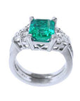 A square emerald on top of the ring, showing its lateral gallery and band ring profile.
