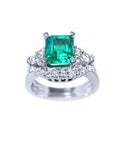Emerald-cut vivid bluish green emerald ring with matching diamond band in white gold.