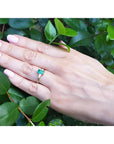 1.05 ct. natural emerald ring with side baguette diamonds in 14K yellow gold on a hand.