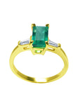 14k yellow gold ring with a natural colombian emerald on a white background.