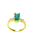 14k yellow gold ring with a natural colombian emerald on a white background.