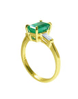 This yellow gold emerald ring displays the top and side profile on a white background