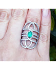 Silver ring with a green fire colombian emerald on a hand, branded 'Emeralds & Jewelry Corp'.