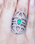 Silver ring with a green fire colombian emerald on a hand, branded 'Emeralds & Jewelry Corp'.