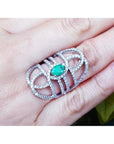 Silver ring with a Muzo born colombian emerald on a hand.
