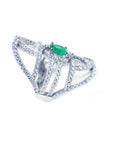 A silver ring with natural emerald center stone and diamond accents on a white background.