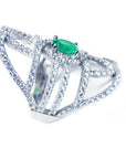 A silver ring with natural emerald center stone and diamond accents on a white background.
