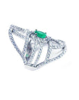 A silver ring with natural emerald center stone and diamond accents on a white background.