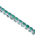 A tennis bracelet with round cut natural colombian emeralds crafted in in 14k white gold.