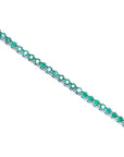 Emerald tennis bracelet topside view position on a white background.