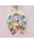 18K yellow gold horseshoe pendant with emeralds, diamonds, and two horse heads.