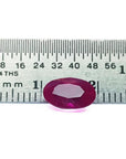 2.12 carat loose natural oval-cut ruby gemstone with rich red color, displayed on a ruler.