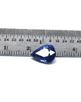 Deep blue pear-cut natural sapphire gemstone next to a ruler, showing its size and brilliant facets.
