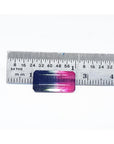Emerald cut 6.11 ct natural loose watermelon tourmaline with bluish green and red-orange hues, measured against a ruler.