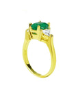 18K yellow gold three-stone ring with a natural Colombian emerald and two trillion-cut diamonds.