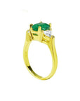 18K yellow gold three-stone ring with a natural Colombian emerald and two trillion-cut diamonds.