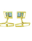 The underside view of a pair of yellow gold emerald cufflinks.
