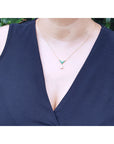 Mother's Day gift diamond necklace dangling from a V style center piece with natural round cut emeralds prong set in 14k yellow gold