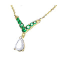 14k yellow gold necklace dangling a tea drop natural from a V style center piece with natural round cut emeralds