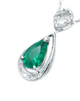 Teardrop-shaped emerald pendant with diamond accents on a white background