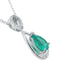 White gold pendant with a natural colombian emerald on a white background.
