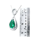 1.35 ct natural pear-shaped emerald pendant necklace with diamond bail in 14K white gold, shown with ruler.