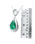 1.35 ct natural pear-shaped emerald pendant necklace with diamond bail in 14K white gold, shown with ruler.