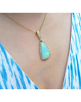 8.05 ct. pear-shaped Australian opal pendant with diamond halo on an 18K yellow gold chain.