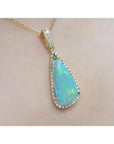 Pear-shaped Australian opal pendant with bluish-green play of colors, halo diamonds, and 18K yellow gold chain.