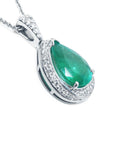 Silver pendant with a green teardrop emerald on a right-side profile visible