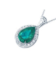 Pear-shaped natural emerald pendant with diamond halo in 14K white gold.