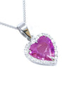 Natural pink sapphire heart pendant encircled by a halo of natural diamonds crafted in 18k white gold.