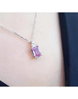 2.01 ct. natural pink sapphire emerald cut necklace in 14K white gold, worn on a person.