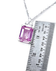 Pink sapphire emerald cut necklace in 14K white gold, shown with a ruler for scale.