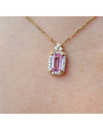 Natural pink sapphire and diamonds pendant necklace on a person's neck.