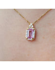 Natural pink sapphire and diamonds pendant necklace on a person's neck.